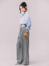 Model wearing the Youmsara Deux Bleu Shirt paired with the Valenza grey wool–silk wide-leg pleated trousers on a studio background.